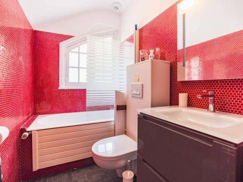 La salle de bains rouge est pourvue de toilettes et d'un lavabo. dans l'établissement Appartement 3 chambres avec parking au Touquet - FR-1-821-2, à Le Touquet-Paris-Plage