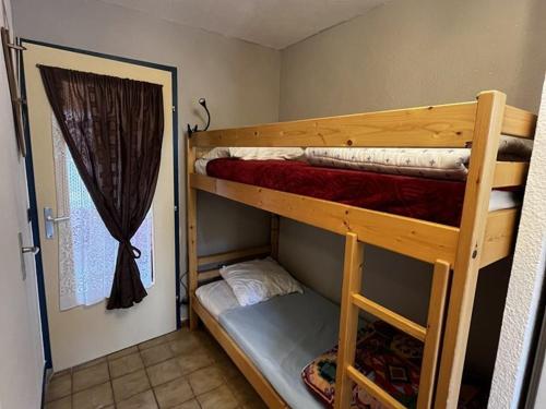 Cette chambre dispose de lits superposés avec 2 lits superposés et une porte. dans l'établissement Studio 4 pers. près des pistes, tout équipé - FR-1-733-161, à Crest-Voland