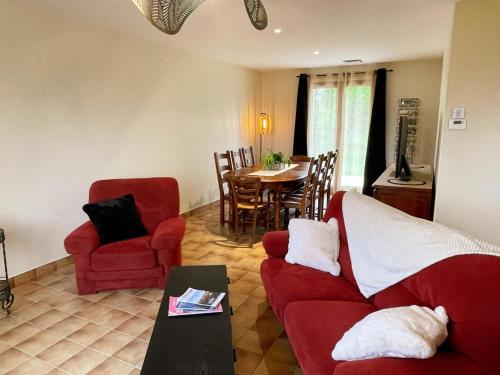 un salon avec un canapé rouge et une table dans l'établissement Gîte avec SPA et sauna dans le Val de Loire - FR-1-381-607, à Beaumont-la-Ronce