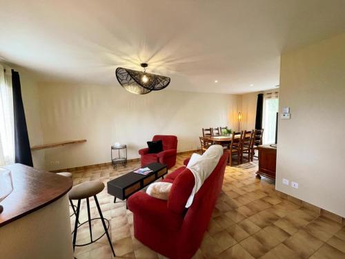 un salon avec un canapé rouge et une table dans l'établissement Gîte avec SPA et sauna dans le Val de Loire - FR-1-381-607, à Beaumont-la-Ronce