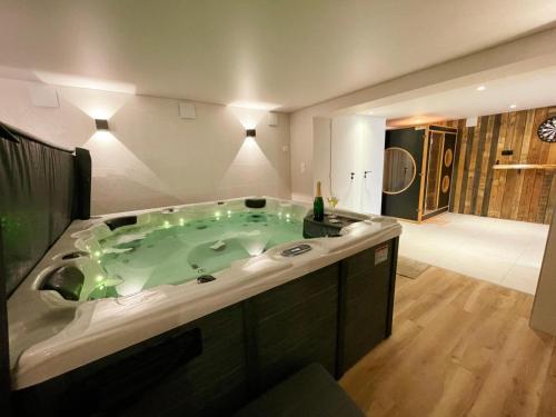 La grande salle de bains est pourvue d'une grande baignoire verte. dans l'établissement Gîte avec SPA et sauna dans le Val de Loire - FR-1-381-607, à Beaumont-la-Ronce