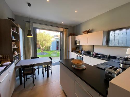 une cuisine avec un comptoir noir et une table dans l'établissement Charmante maison Arcachonnaise, 4 chambres, 300m de la plage - FR-1-374-231, à Arcachon