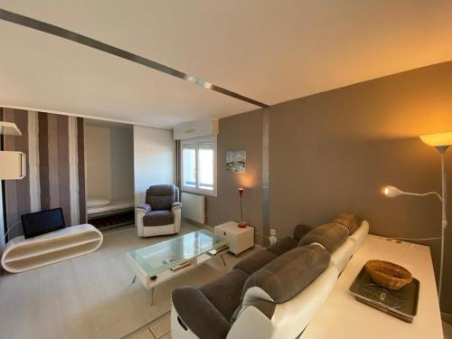 un salon avec un canapé et une table dans l'établissement Appartement spacieux à Capbreton avec terrasse, animaux acceptés, parking sécurisé - FR-1-413-253, à Capbreton