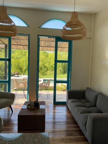 a living room with a couch and some windows at Piscina privada in Alcalá