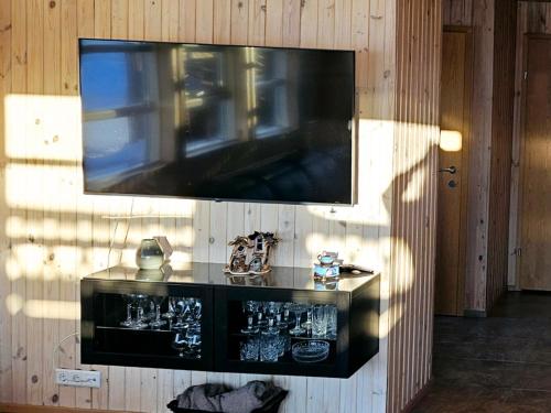 a flat screen tv hanging on a wall with atainment at Aurora Vacation Homes Fagravik in Akureyri
