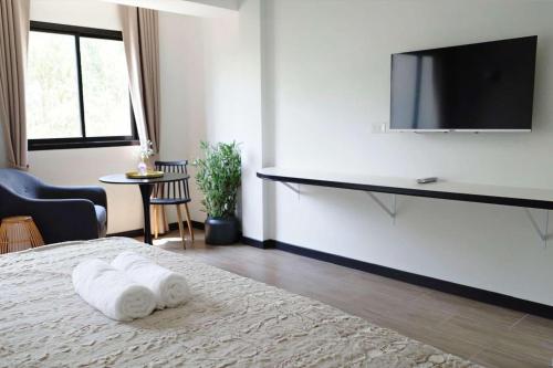 a bedroom with a bed and a flat screen tv at VIYA residence วิยา เรสซิเด้นท์ in Ban Phala