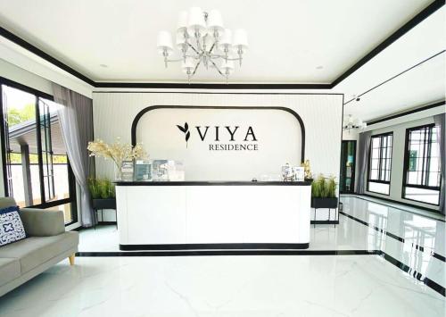 a lobby with a white reception desk in a building at VIYA residence วิยา เรสซิเด้นท์ in Ban Phala