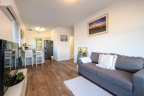a living room with a couch and a kitchen at B1 Airport Haven - Free Parking & Modern Serenity in Perth