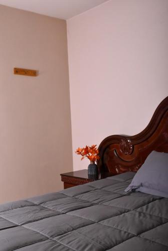 a bedroom with a bed with a wooden headboard at CASA EN LA MEjOR UBICACION, CONSULADO in Hermosillo