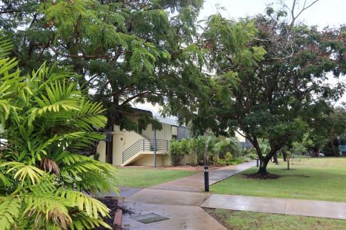 a building with trees and a sidewalk in a park at CDU Village Casuarina Campus in Jingili