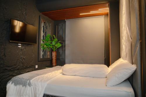 a bedroom with a bed with a window and a tv at Apartment Borneo Bay City - AH Property Indonesia in Balikpapan