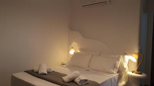 a white bedroom with a bed with towels on it at Chill Out Studio in Mýkonos City