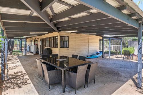 a patio with a table and chairs and a pool at Majuvary in Dunsborough