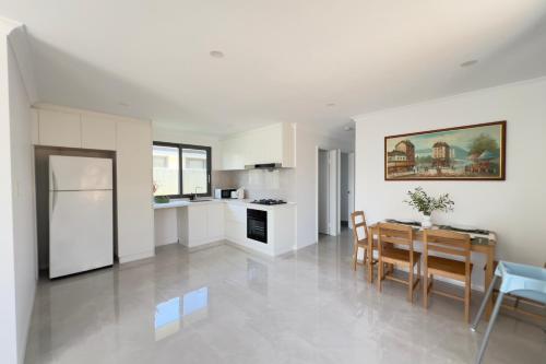 a kitchen and dining room with a table and chairs at A2 Airport 2BR Haven - Garden & Parking in Perth