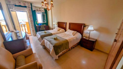 a hotel room with two beds and a couch at Viña Home in Torre del Mar
