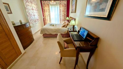 a bedroom with a desk and a bed with a laptop at Viña Home in Torre del Mar