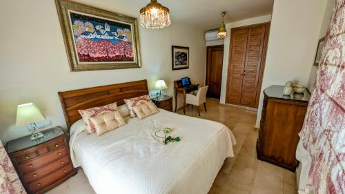 a bedroom with a large white bed with a table at Viña Home in Torre del Mar