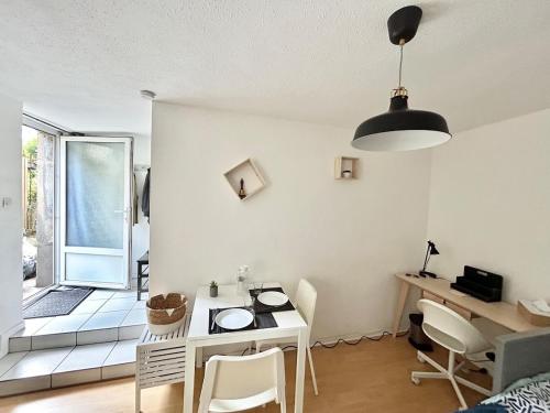un salon avec une table et une chambre avec une fenêtre dans l'établissement Appartement au cœur du JARDIN, à Nancy