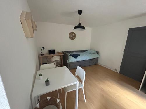 Cette petite chambre comprend une table et un lit. dans l'établissement Appartement au cœur du JARDIN, à Nancy