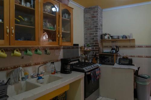 a kitchen with a sink and a stove at Nomades Hostel in Panajachel