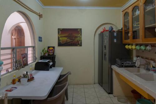 a kitchen with a counter and a sink and a refrigerator at Nomades Hostel in Panajachel