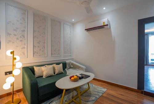 a living room with a green couch and a table at Riverside Bliss at Sukoon - A Riverside Retreat in Haridwār
