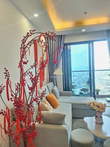 a living room with a white couch and a large window at TC Apartment & Homestay in An Khê