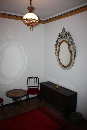 a room with a mirror and a table and a chair at Dar El Mouhit in Sale