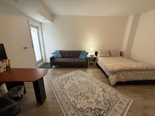 a living room with a couch and a bed at Brand New 2 story unit in Richmond Hill