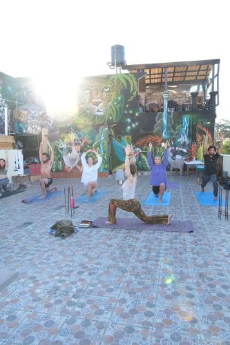 a group of people doing yoga in front of a mural at Nomades Hostel in Panajachel