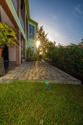 a house with the sun setting behind a brick driveway at Cathartica in Quatre Vents