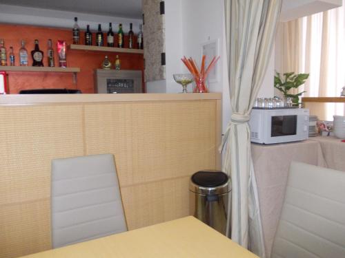 a kitchen with a table and a counter with a microwave at Hotel Catania Town in Catania