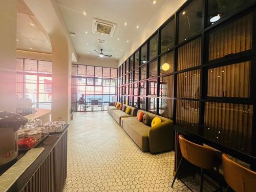 a library with couches and chairs in a room at 14 Sathorn Hotel No-Parking in Bangkok