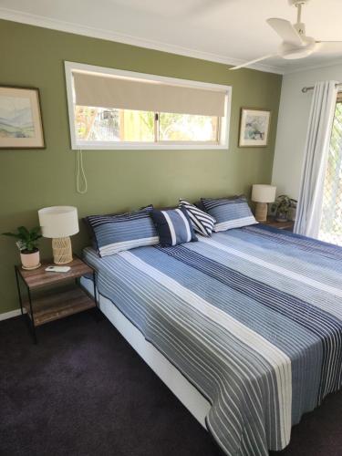 a large bed in a bedroom with a window at Bushland View Retreat in Ocean Shores