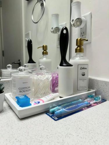 a bathroom counter with toothbrushes and other bathroom items at Resort style 1 King and Twin Apt w Gym Pool Hot Tub in Salt Lake City