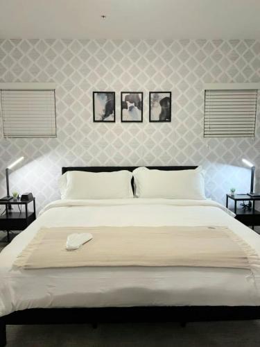 a bedroom with a large white bed with three pictures on the wall at Resort style 1 King and Twin Apt w Gym Pool Hot Tub in Salt Lake City