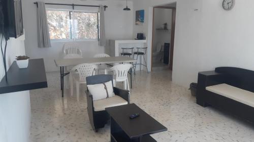 un soggiorno con tavolo, sedie e divano di Relaxing Place Beach apartment 21 a San Lorenzo