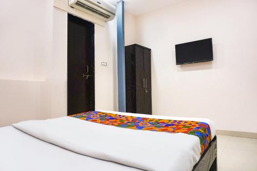 a bedroom with a bed with a colorful blanket at FabHotel Rachana Residency - Nr Shivaji Nagar Metro Station and Railway Station in Pune