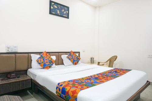 a bedroom with a large white bed with colorful pillows at FabHotel Rachana Residency - Nr Shivaji Nagar Metro Station and Railway Station in Pune