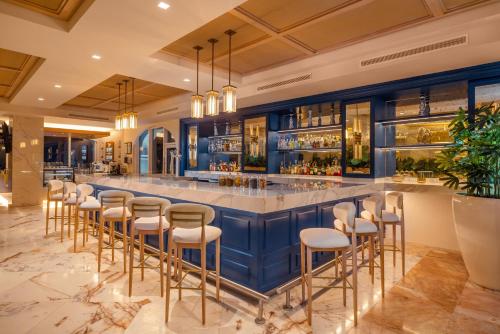 a bar with stools in a restaurant with blue walls at Cozumel Palace-All Inclusive in Cozumel