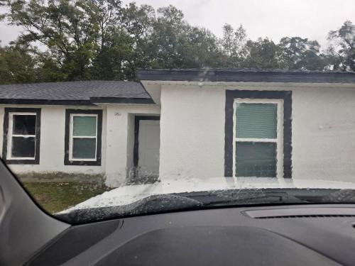 a house with snow on the roof of a car at Cozy duplex near the Ocala Airport in Ocala