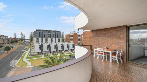 a balcony with a table and chairs and a building at Unit 24 Fountain Court in Port Macquarie