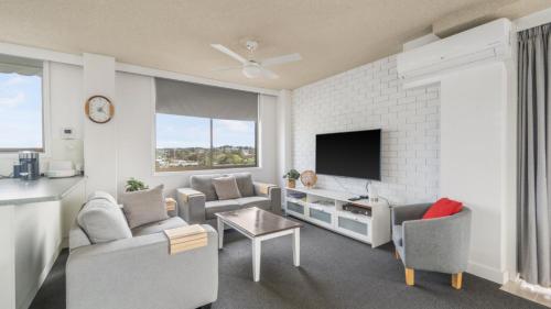 a living room with a couch and a tv at Unit 24 Fountain Court in Port Macquarie