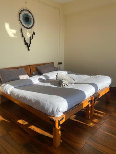 a large bed sitting on a wooden floor in a room at Simba Jungle Lodge, Binsar Wildlife Sanctuary in Binsar