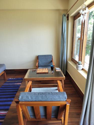 a living room with a table and a couch at Simba Jungle Lodge, Binsar Wildlife Sanctuary in Binsar