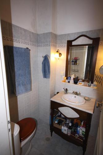 a bathroom with a sink and a toilet and a mirror at Apollonos Seafront Apartment in Ermoupoli