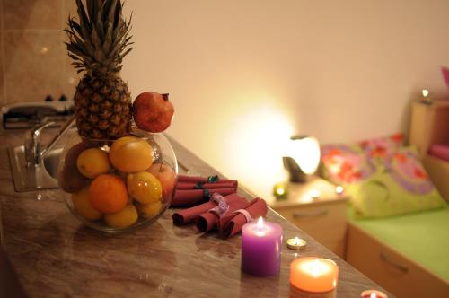 a bowl of fruit on a counter with a candle at IWA CENTAR Apartments & Wellness in Vrnjačka Banja