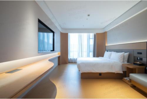 a hotel room with a bed and a large window at JI Shanghai International Tourism Liufeng Highway Hotel in Shanghai