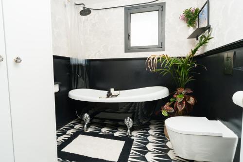 a black and white bathroom with a sink and a tub at Penthouse Living in the Heart of Nicosia in Nicosia