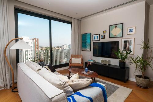 a living room with a white couch and a large window at Penthouse Living in the Heart of Nicosia in Nicosia